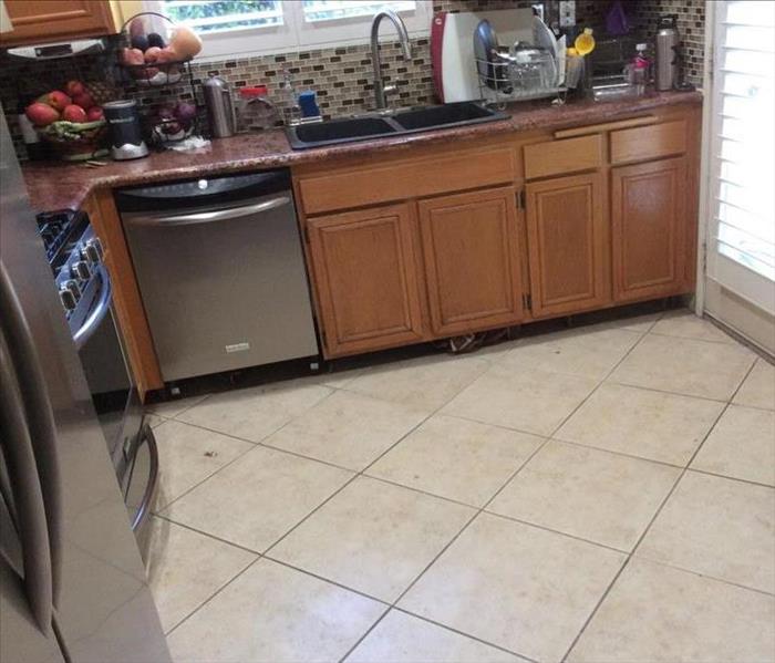 Kitchen with wood cabinets and household items on counter