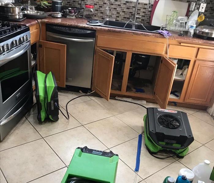 Drying equipment set up in a kitchen with cabinet doors open
