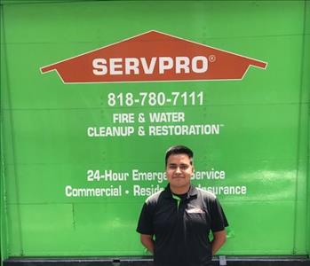 Crew Chief, Alexis, standing in front of Green Box Truck